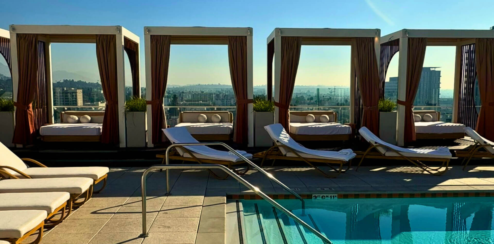 Custom cabanas beside a rooftop hotel pool
