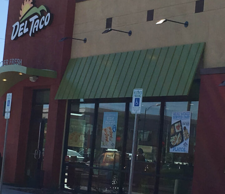 Green standing-seam metal awning above an entrance, Orange County