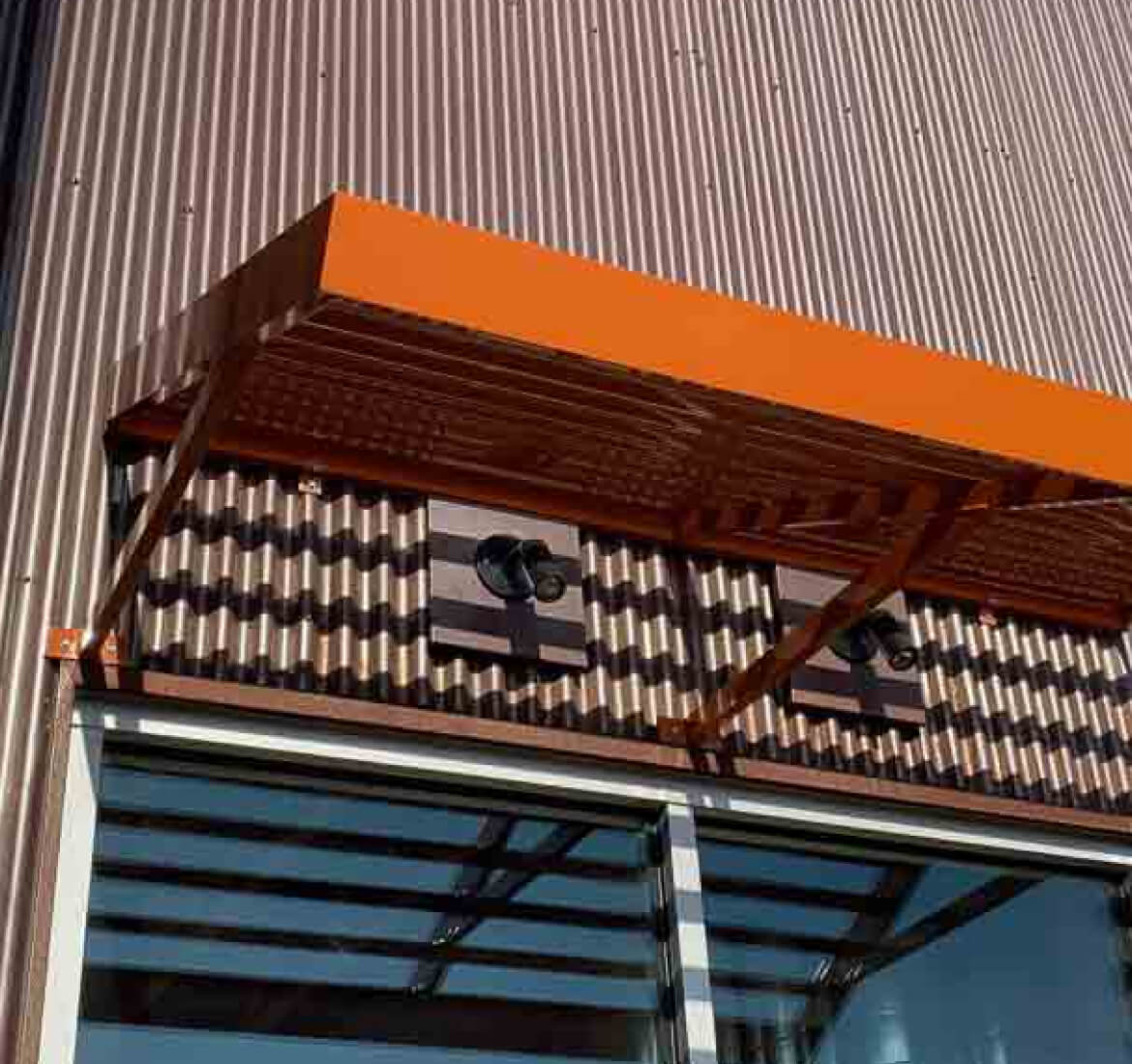 Orange louvered metal canopy above a storefront, Ventura County