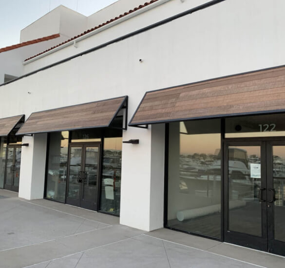 Wood-finish metal awnings above glass storefronts, Orange County