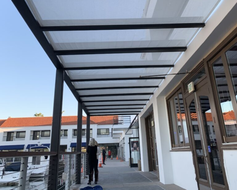 Translucent rigid-panel cover over an elevated commercial walkway