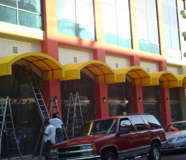 Row of yellow arched canvas storefront awnings, Los Angeles