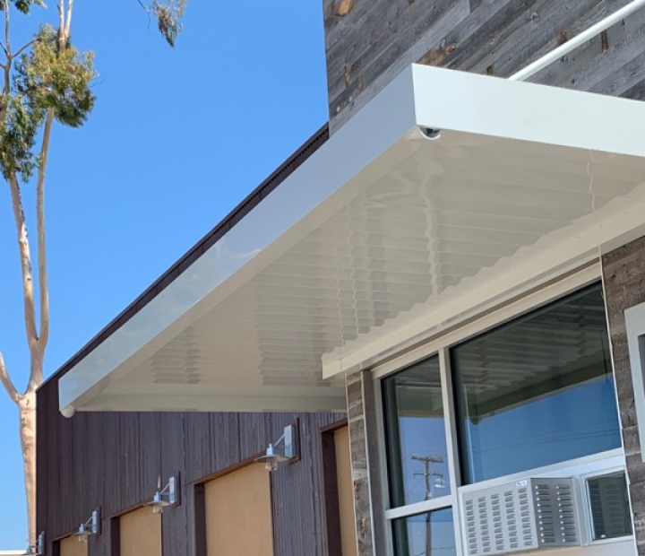 White louvered metal canopy above glass doors, Orange County