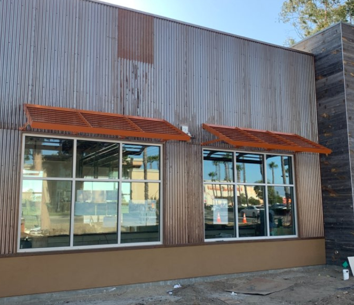 Orange metal canopies on a modern storefront, Orange County