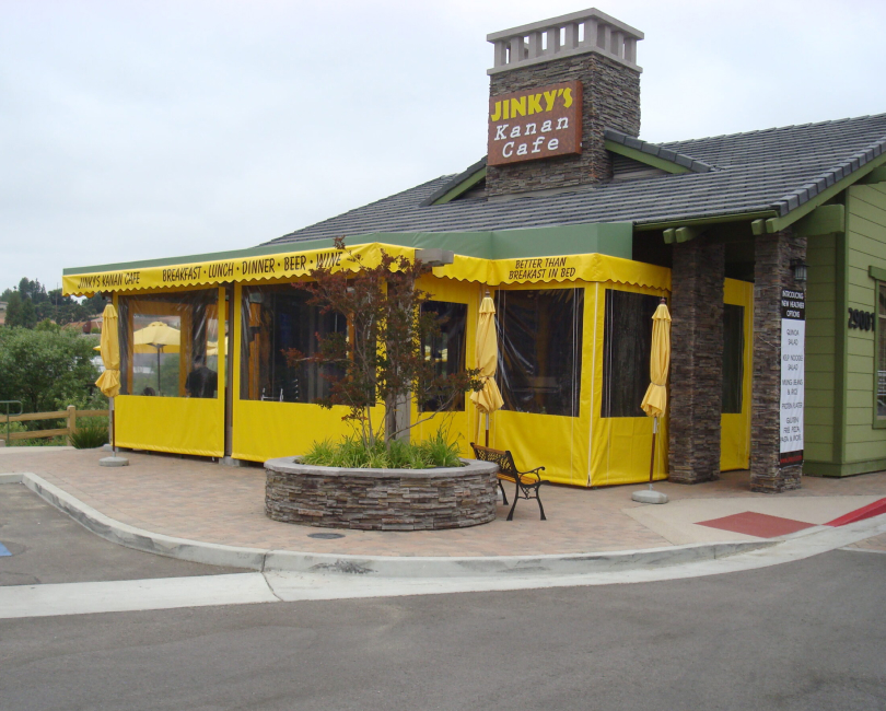 Clear patio shades enclosing a yellow restaurant patio, Ventura County