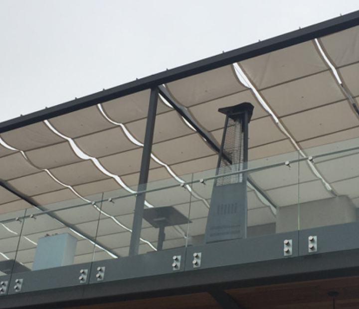 Curved slide-on-wire canopy panels above a patio, San Diego County