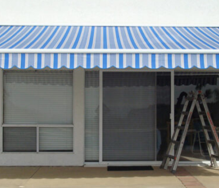 Striped retractable window awning during installation, Orange County