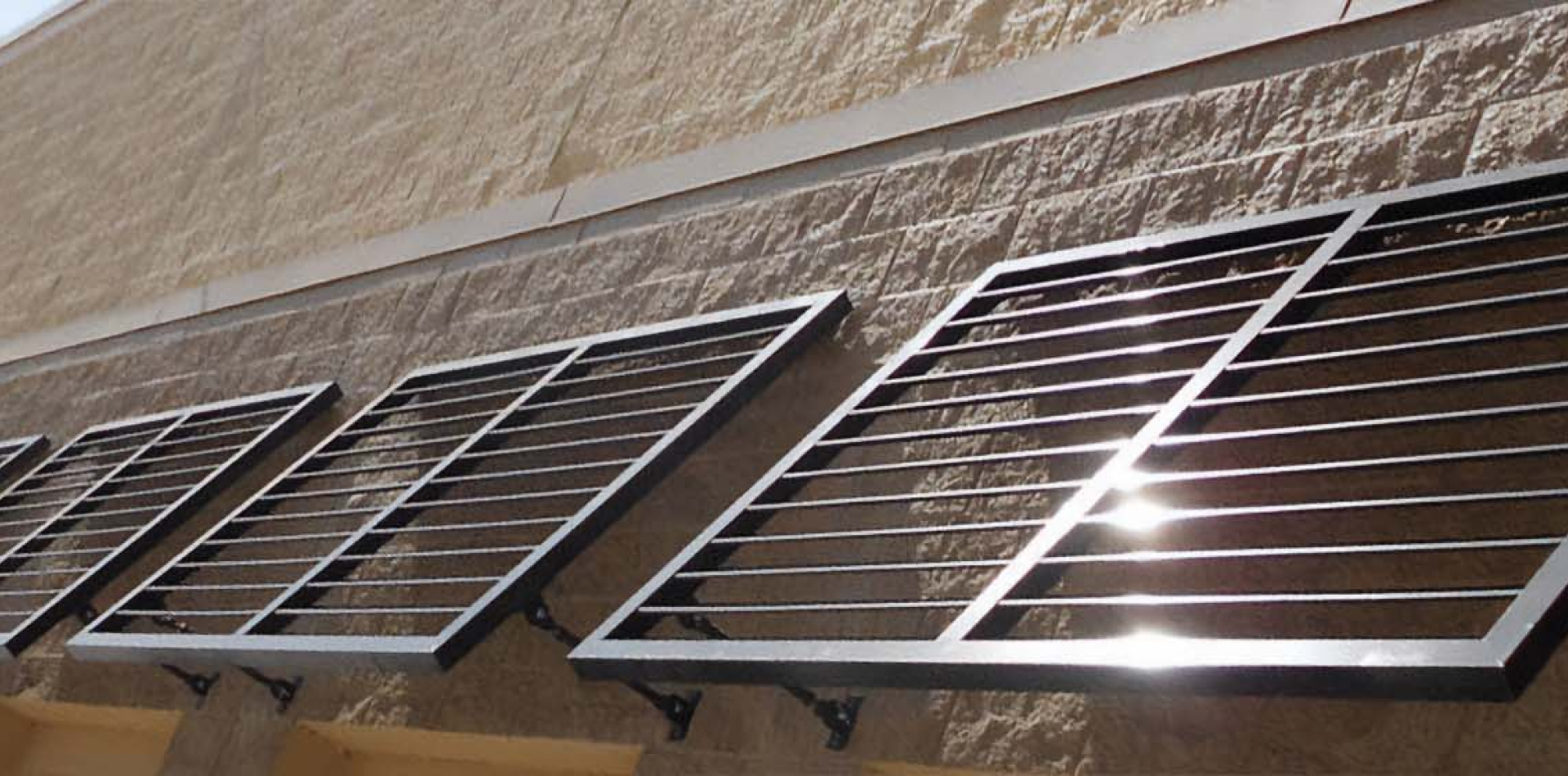 Louvered metal awnings mounted on a masonry wall, Orange County