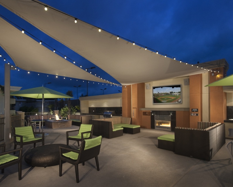 Tensioned shade sails with lights above a hotel patio, Riverside County