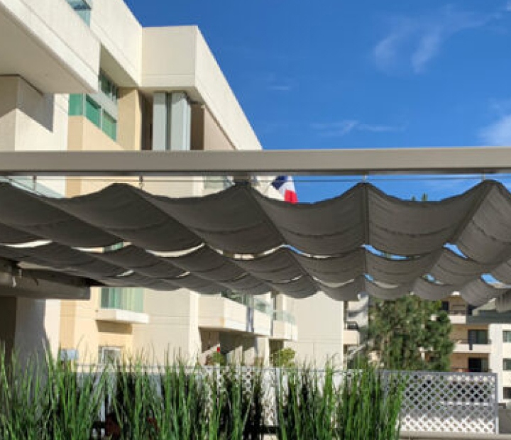 Gray slide-on-wire canopy at a hotel courtyard, San Diego County