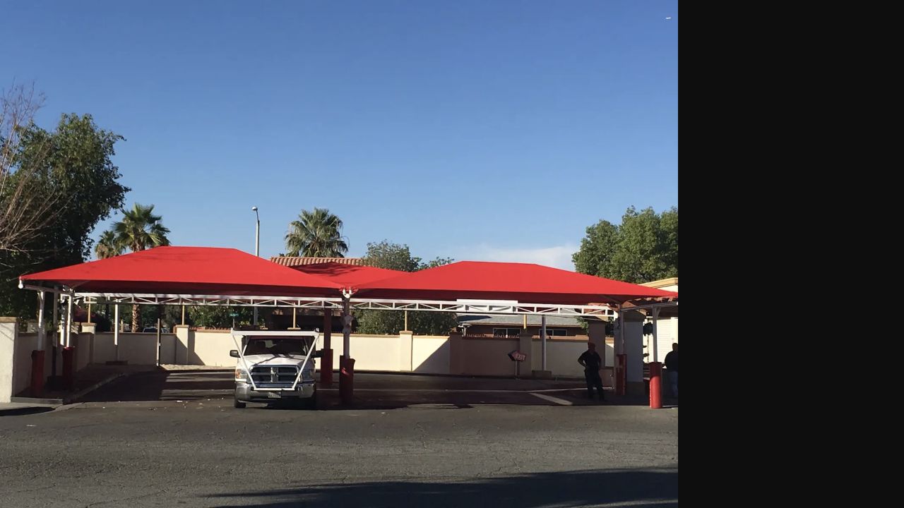 Red tensioned canopies covering active car wash lanes