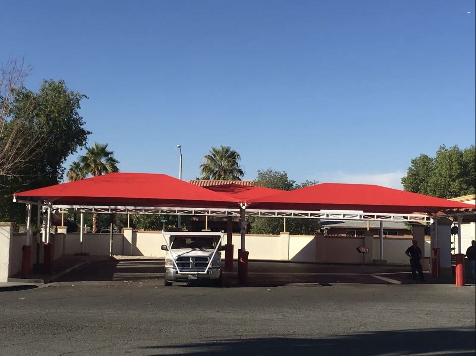 Red fabric canopy covering commercial vehicle service lanes