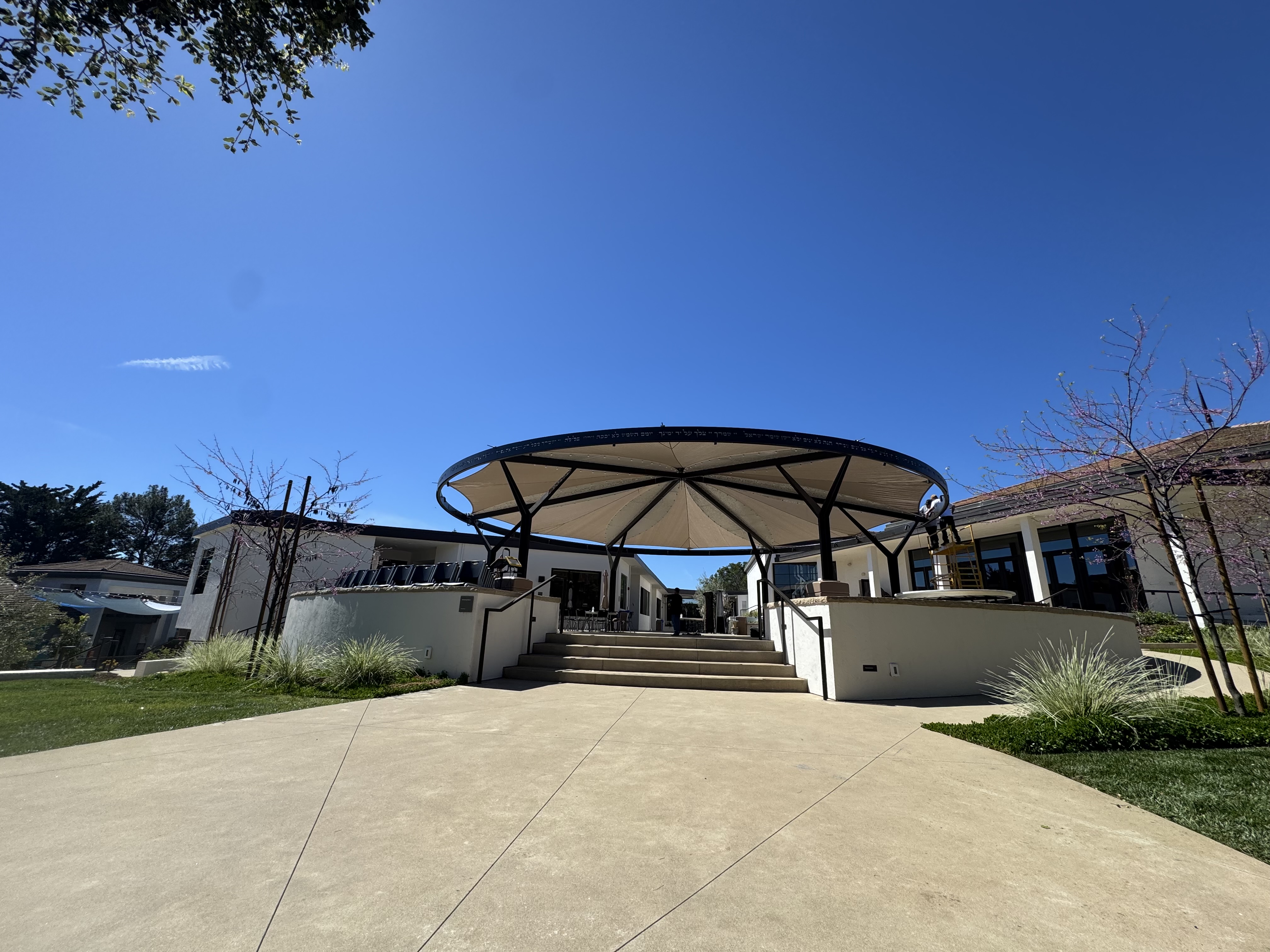 Round fabric canopy integrated into a B'NAI campus courtyard