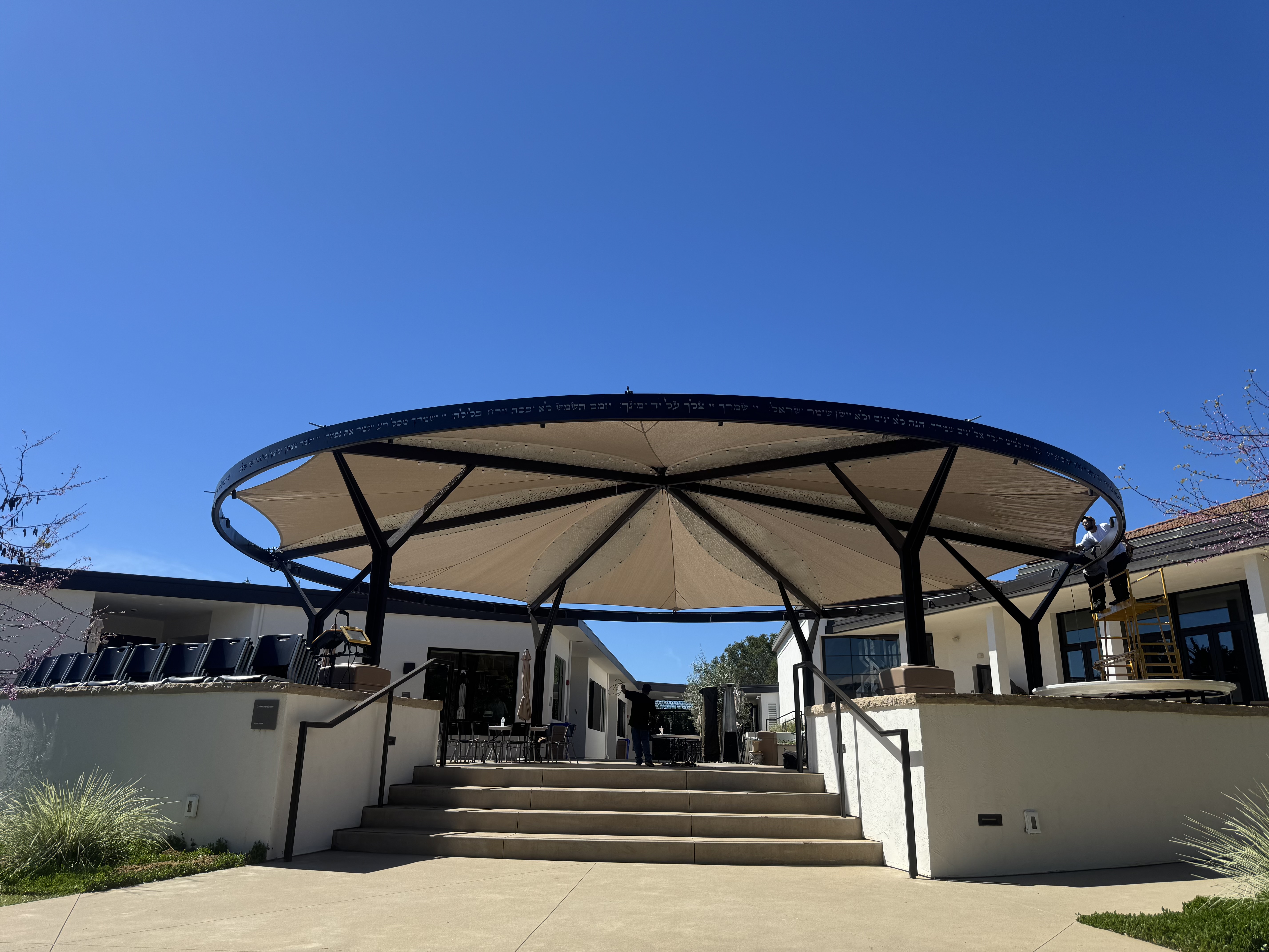 Large circular fabric canopy supported by a custom metal frame at B'nai David-Judea