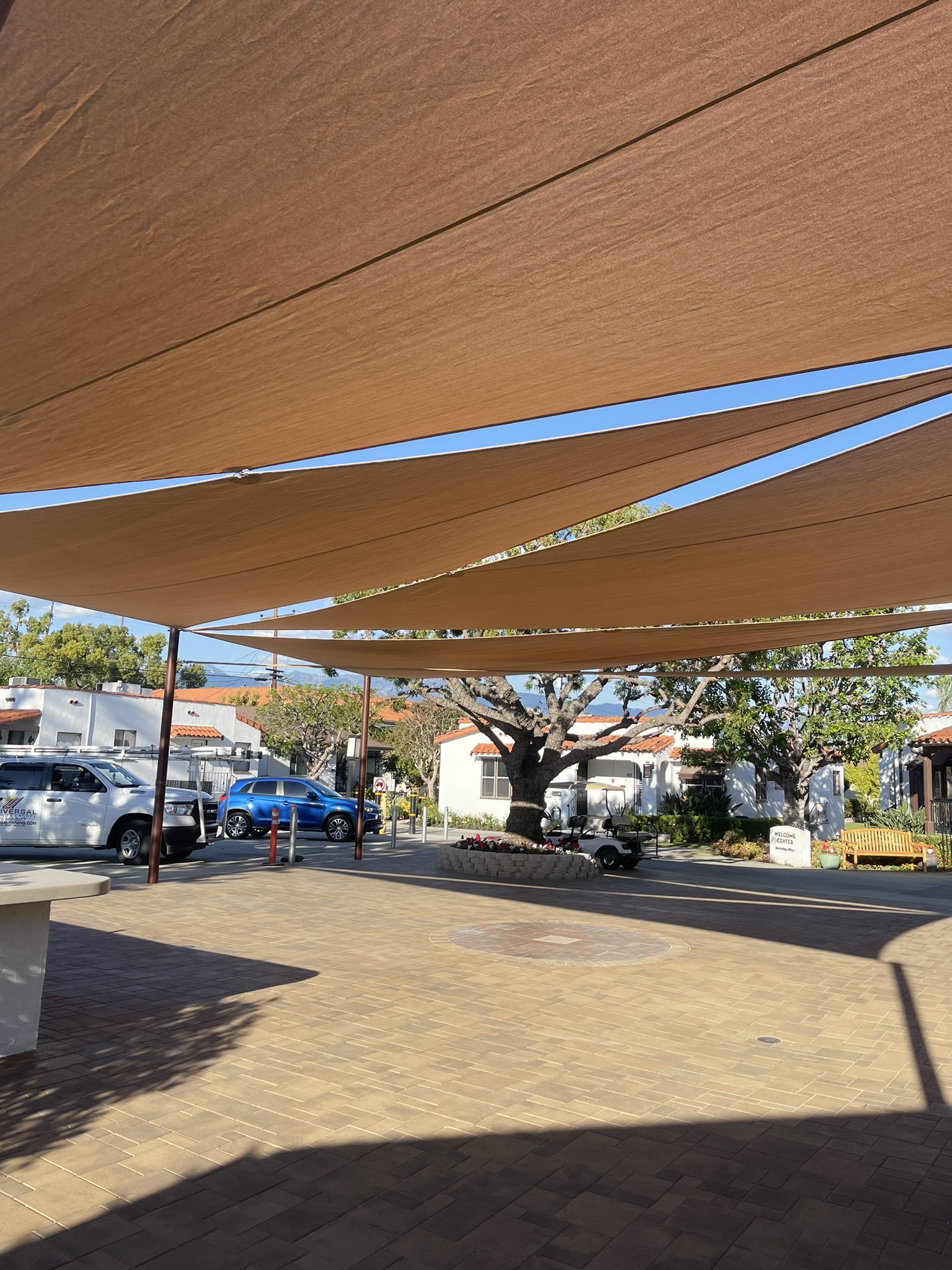 Brown shade sails covering an outdoor healthcare courtyard