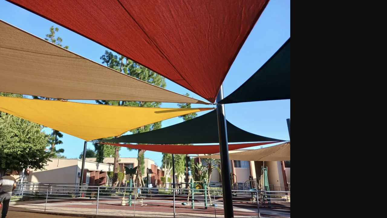 Overlapping blue shade sails installed over a public park area in Sylmar