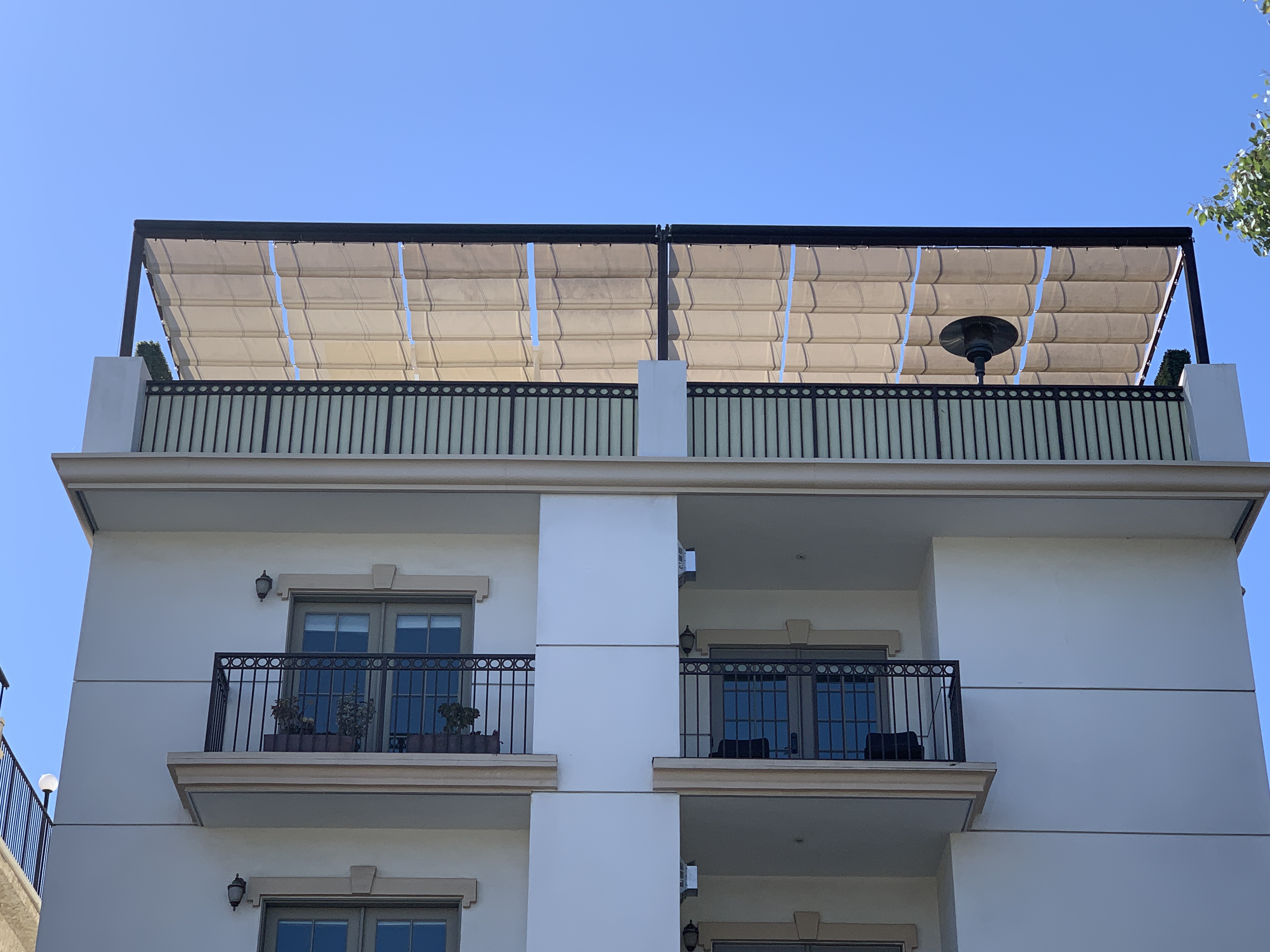 Slide-on-wire fabric canopy installed over a rooftop terrace