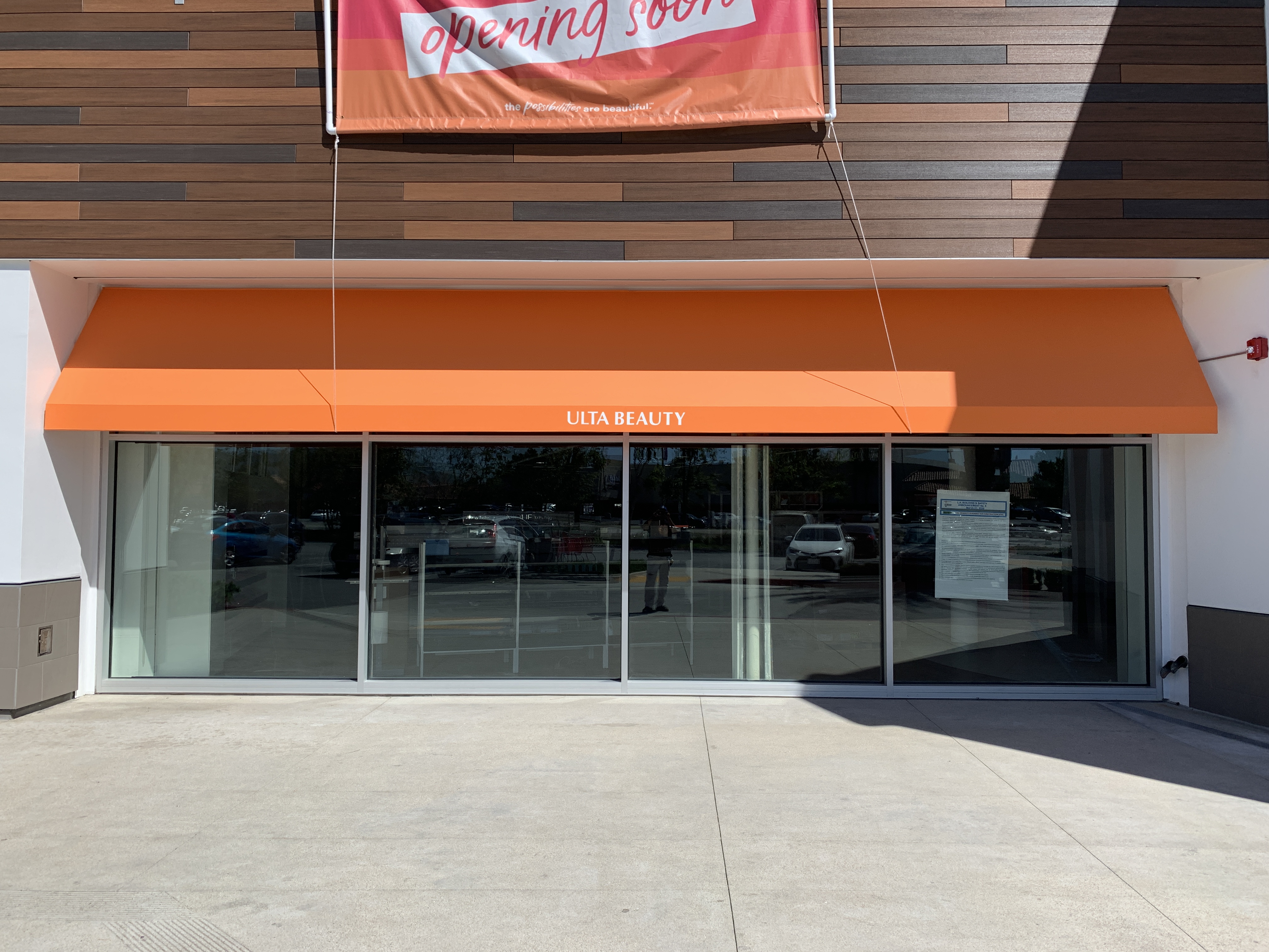Orange branded fabric awning installed at an Ulta Beauty storefront