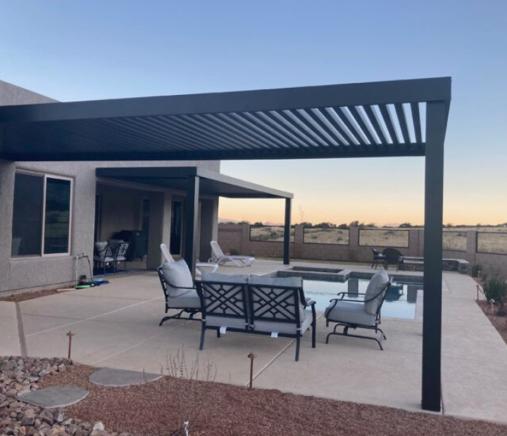 Dark metal trellis with evenly spaced overhead members above an outdoor patio
