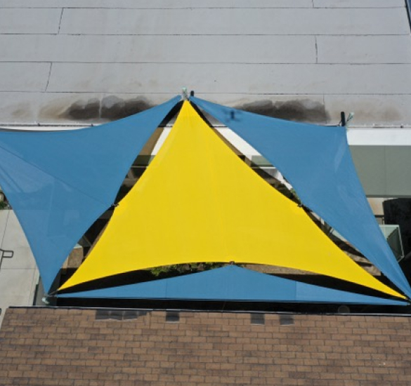 Blue and yellow triangular shade sail installation, Riverside County